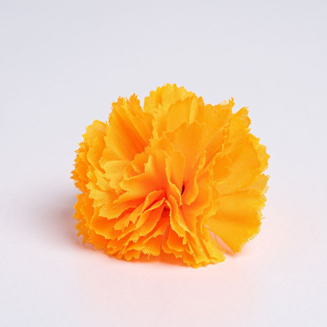 an orange frilly fabric flower