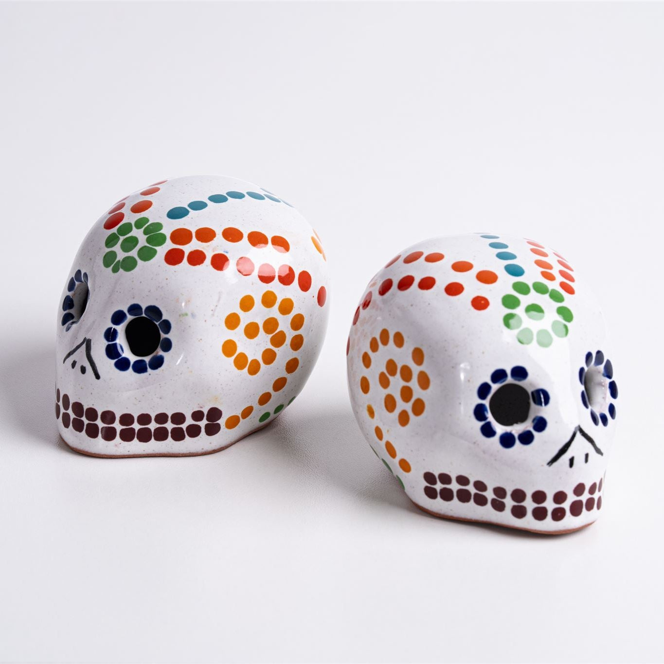 two glass skulls wit colorful dot decorations
